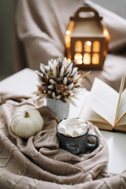 Autunno ancora in vita. Tazza di caffè, fiori, libro e zucca.