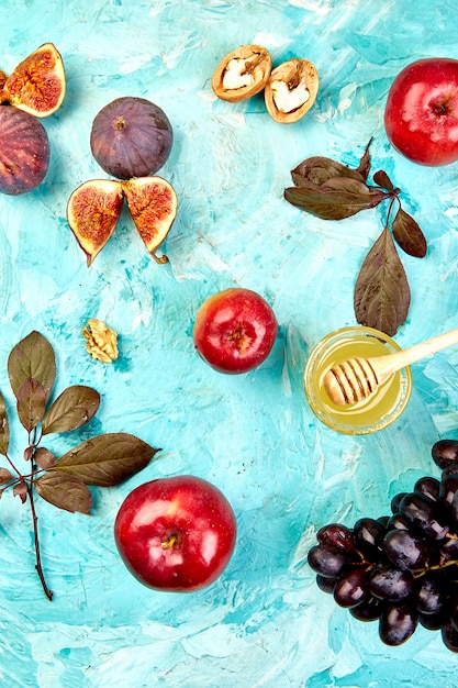 Autunno cibo natura morta con frutta stagione uva, mele rosse e fichi su un tavolo blu.