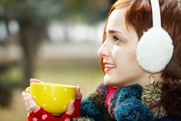 Autunno donna che beve caffè Concetto di caduta di giovane donna che gode di una bevanda calda dalla tazza di caffè usa e getta nel paesaggio autunnale Serena felice razza mista asiatica caucasica modello femminile nel parco forestale della città