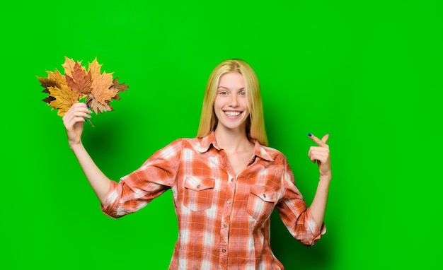 Autunno felice ragazza che si diverte con la caduta delle foglie umore autunnale donna bionda allegra che tiene foglia d'oro