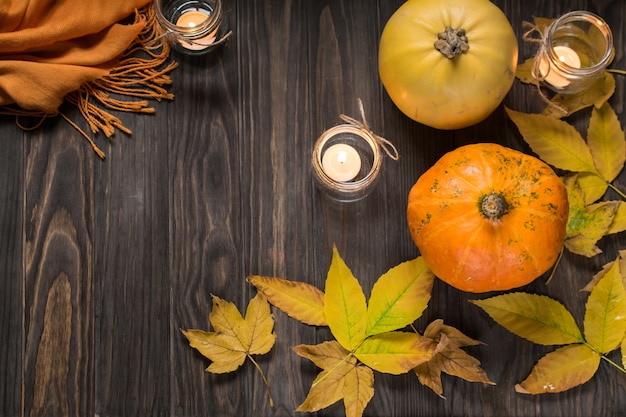 Autunno piatto disteso con zucche, foglie di autunno gialli e candele