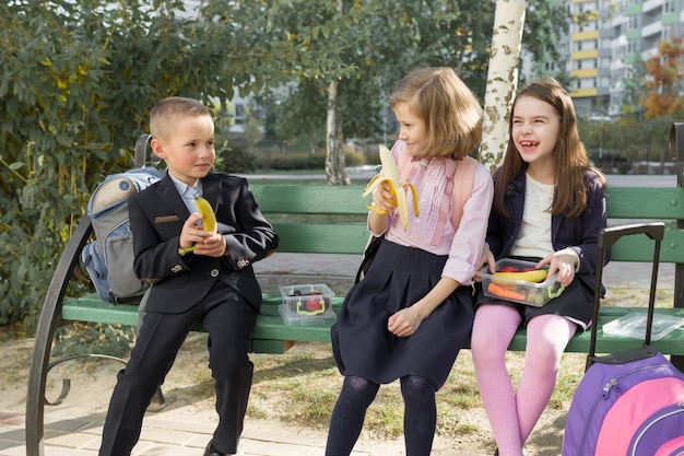 Autunno ritratto di bambini con scatole per il pranzo, zaini scuola.