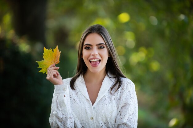 Autunno ritratto di donna allegra con foglie di acero giallo Ritratto di bellezza ragazza con foglie d'autunno