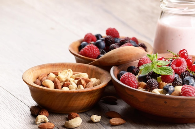 Avena di farina d'avena con frutti di bosco noci e yogurt sul tavolo di legno