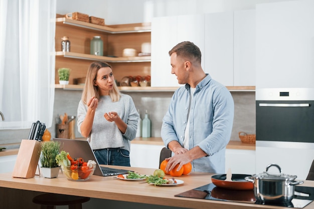 Avere il fine settimana insieme Coppia che prepara il cibo a casa sulla cucina moderna