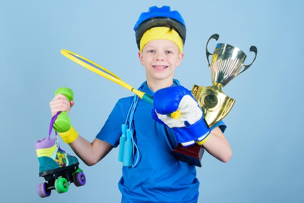 Avere successo in tutto Atleta ragazzo di successo attrezzatura sportiva corda per saltare guantone da boxe racchetta da tennis pattino a rotelle e calice d'oro Successo e premio Successo nello sport Orgoglioso del successo raggiunto