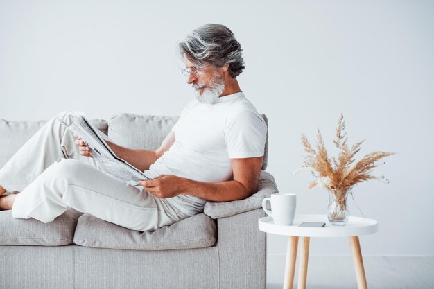 Avere tempo libero Uomo moderno ed elegante anziano con capelli grigi e barba all'interno