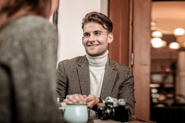 Avere una conversazione. L'uomo sorridente che parla con la donna nel caffè