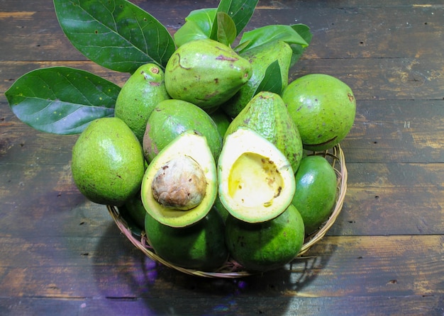 Avocado biologico fresco su sfondo verde, vista dall'alto con spazio per la copia