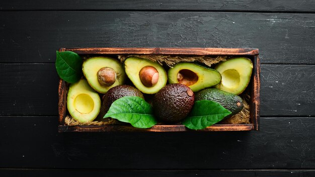 Avocado con foglie nella scatola Stile rustico Vista dall'alto Spazio libero per il testo