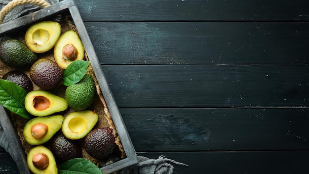 Avocado con foglie nella scatola Stile rustico Vista dall'alto Spazio libero per il testo