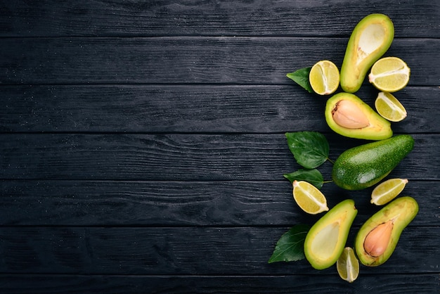 Avocado e lime su uno sfondo di legno Vista dall'alto Spazio libero per il testo