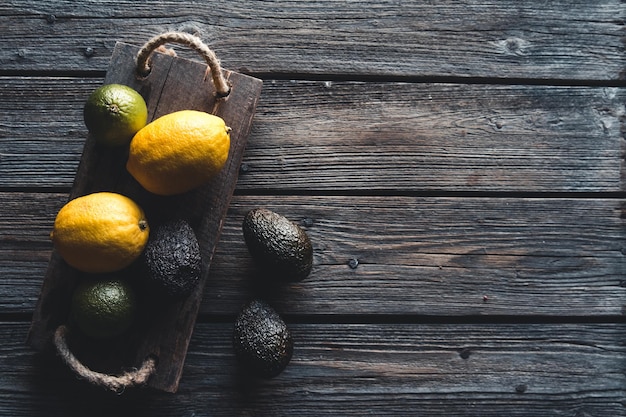 Avocado e limone con coltello sulla vecchia tavola di legno, cibo sano, vegetarianismo, benessere