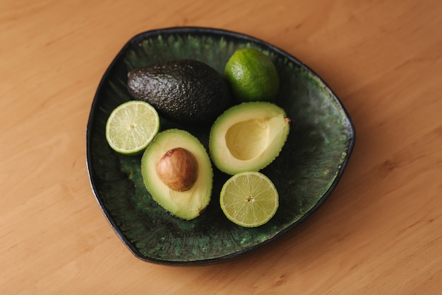 Avocado e metà della calce sulla zolla verde. Concetto di cibo vegetariano. Vista dall'alto