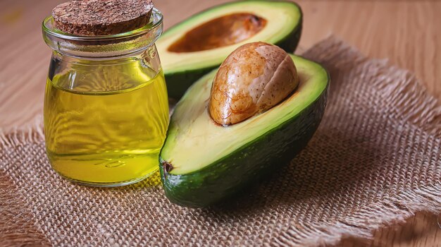 Avocado e olio di avocado su sfondo di legno Fuoco selettivo