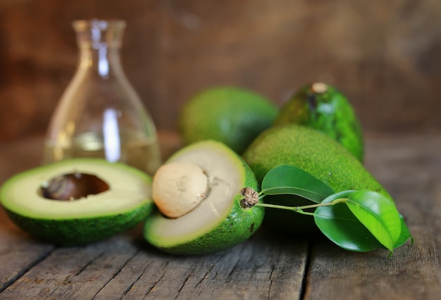 Avocado e olio su fondo in legno