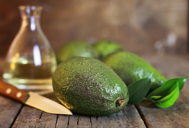 Avocado e olio su fondo in legno