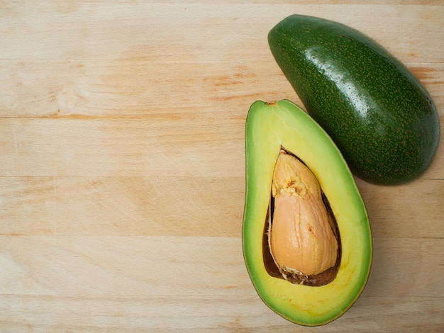 Avocado maturi freschi su fondo di legno