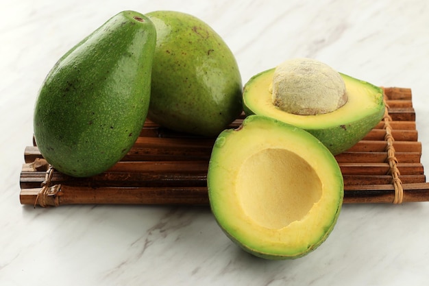 Avocado maturo mezzo sul tavolo di marmo bianco