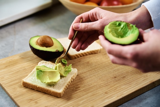 Avocado maturo nelle mani della donna colazione sana