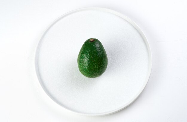 Avocado maturo su un piatto bianco