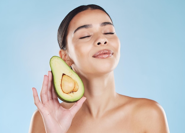 Avocado skincare donna bellezza e benessere cosmetico naturale per una dieta sana risultati femminili e pelle pulita e luminosa su sfondo blu Nutrizione per la cura del corpo e giovane modella toelettatura del viso e fresca