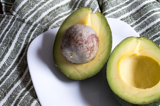 Avocado tagliato a metà su un piatto bianco