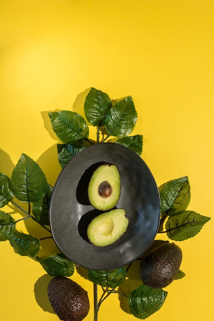 Avocado tagliato su giallo isolato