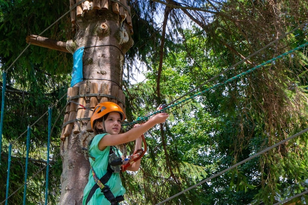 Avventura di arrampicata in parco ad alto filo persone in corso con casco di montagna e attrezzature di sicurezza