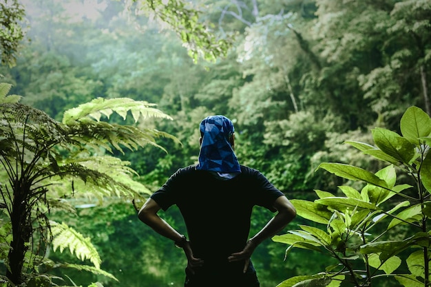 Avventuriero su una foresta verde che guarda il fiume