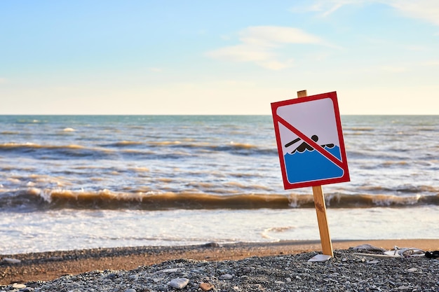 Avvertimento nessun segno di nuoto con forte onda del mare sullo sfondo della spiaggia