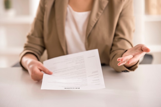 Avvicinamento. Giovane riassunto della tenuta della donna di affari in ufficio.