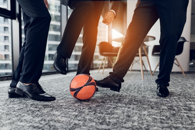 Avvicinamento. Gli uomini in pantaloni rigorosi e scarpe nere giocano a pallone.