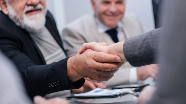 Avvicinamento. stretta di mano di uomini d'affari durante una riunione di lavoro. il concetto di cooperazione