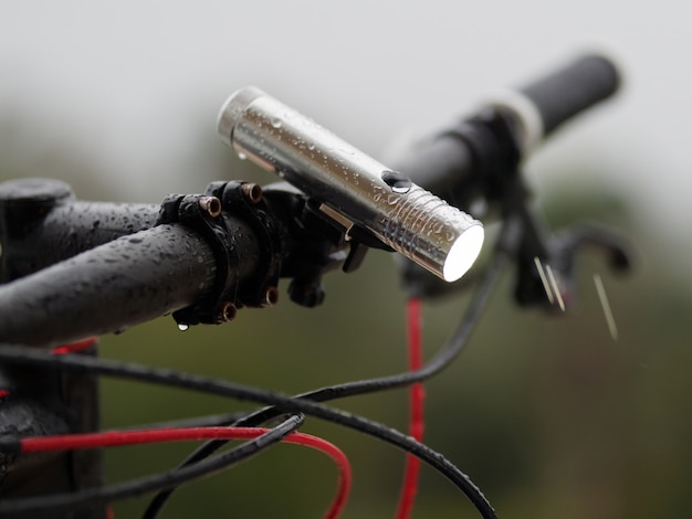 Avvicinamento. Torcia bagnata sulla bicicletta. al di fuori. Serata piovosa.