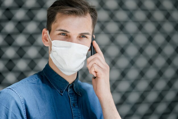 Avvicinamento. un giovane con una maschera protettiva che ti guarda. foto con copia-spazio