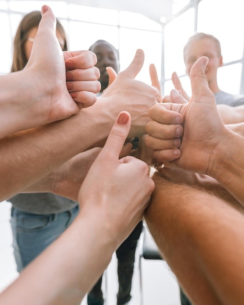 Avvicinamento. un gruppo di giovani felici che mostrano il loro successo. il concetto di lavoro di squadra