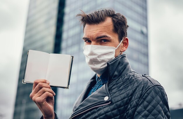 Avvicinamento. un uomo con una maschera protettiva che mostra il suo passaporto. foto con copia-spazio