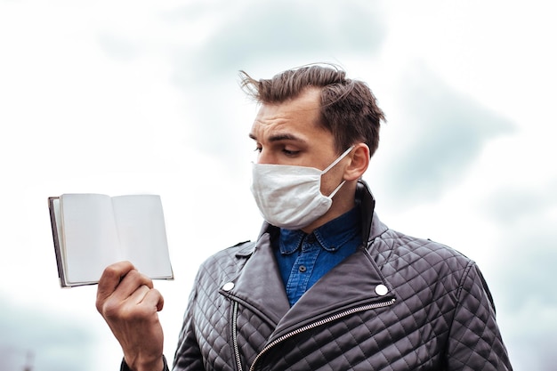 Avvicinamento. un uomo con una maschera protettiva che presenta il suo passaporto. foto con copia-spazio