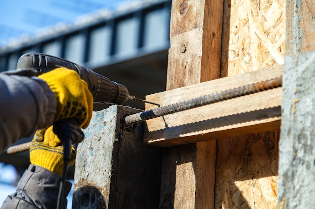 Avvitando una vite in una tavola di legno, da vicino