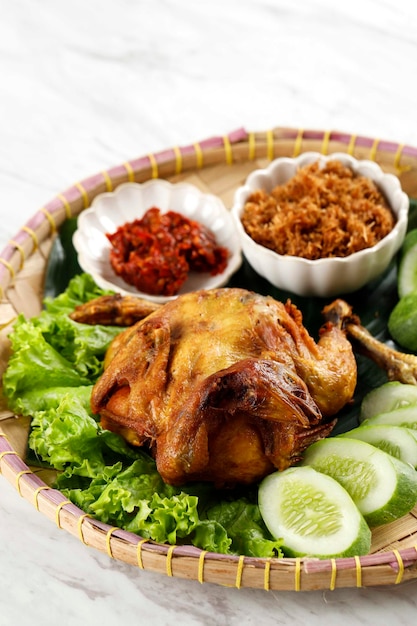Ayam Ingkung Goreng o Bakakak Hayam Pollo intero fritto Ricetta tradizionale indonesiana solitamente servita con sambal e verdure