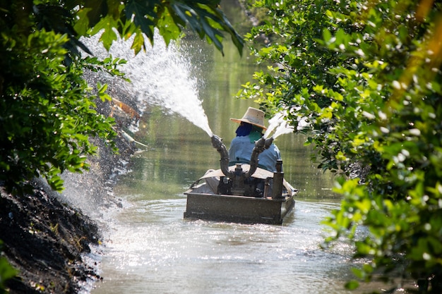 Azienda agricola d&#39;innaffiatura con la barca nella tecnologia dell&#39;agricoltura della Tailandia