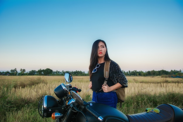 Azionamento della giovane donna con la motocicletta sulla via, godente della libertà e dello stile di vita attivo.