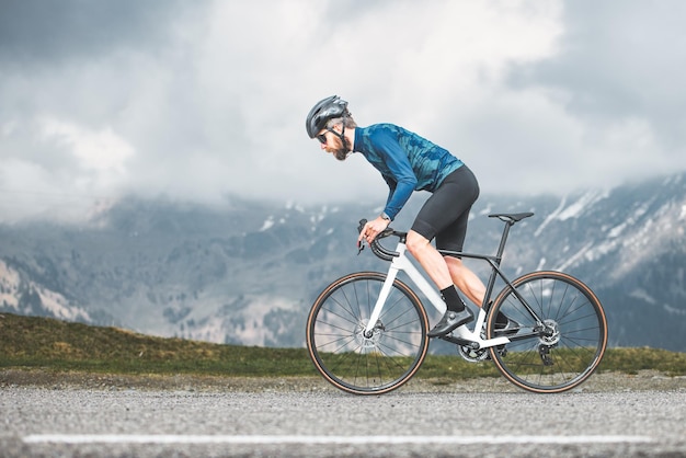 Azione sportiva di un ciclista su strada negli altopiani