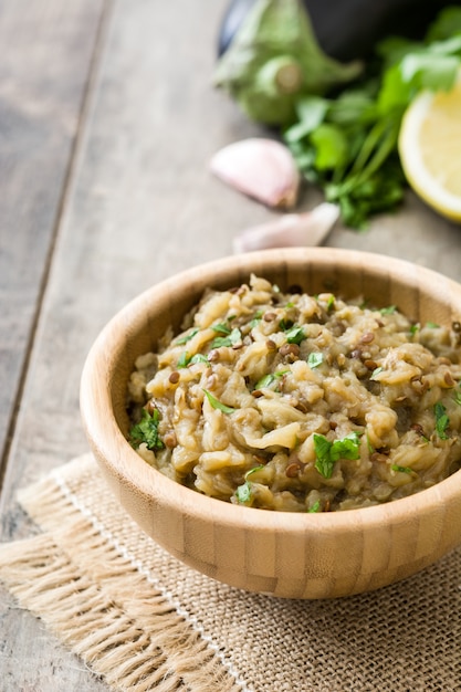 Baba ganoush in ciotola e pane della pita sulla tavola di legno