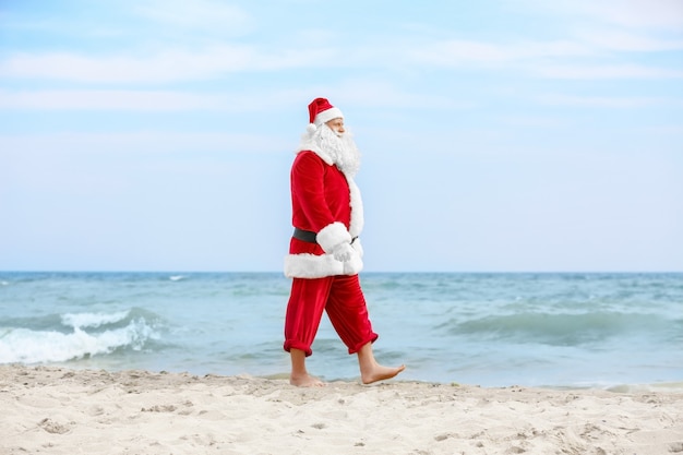 Babbo Natale autentico che cammina sulla spiaggia