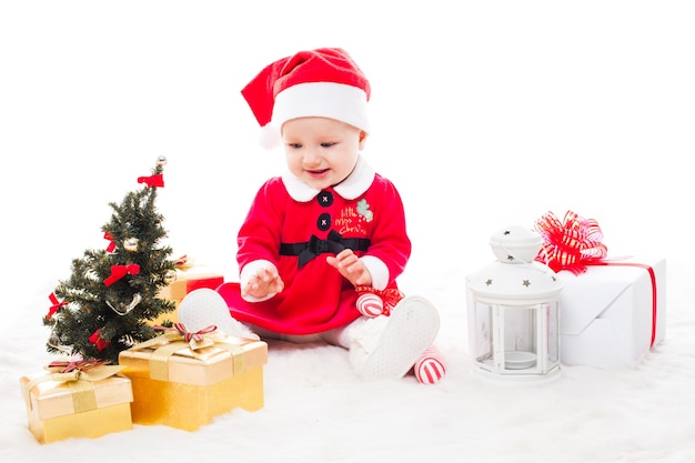 Babbo Natale bambina con confezione regalo e decorazioni natalizie su una pelliccia