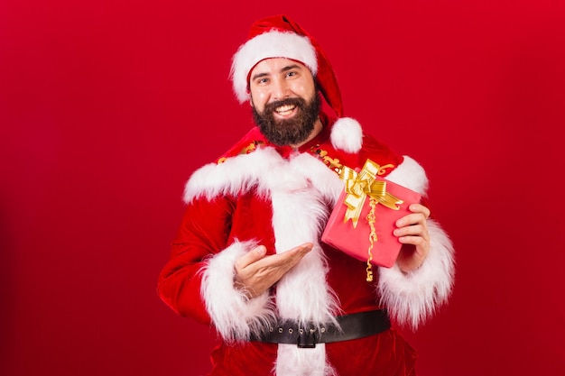 Babbo Natale brasiliano giovane uomo caucasico in possesso di regalo rosso