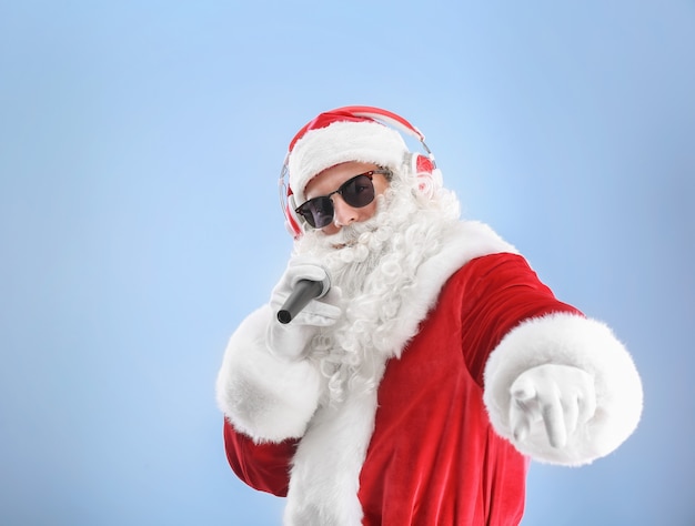 Babbo Natale canta canzoni di Natale su uno sfondo colorato color