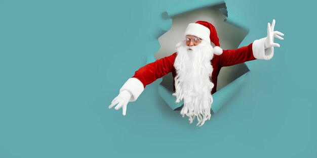 Babbo Natale che dà una occhiata attraverso un buco di carta mentre gesticola il concetto di pubblicità di natale delle mani